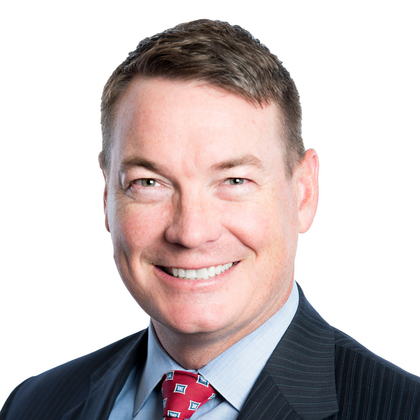 A man in a suit and tie is smiling for the camera.