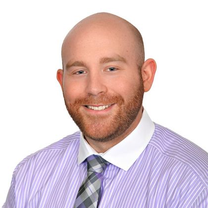 A man in a suit and tie is smiling for the camera.