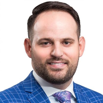 A man in a suit and tie is smiling for the camera.