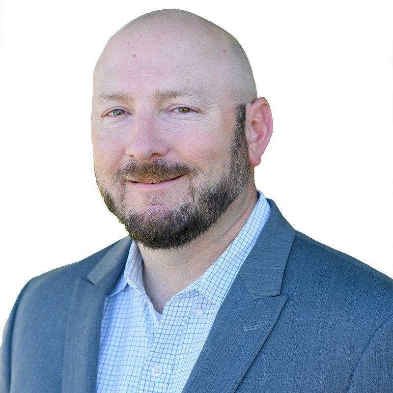 A man in a suit and tie is smiling for the camera.
