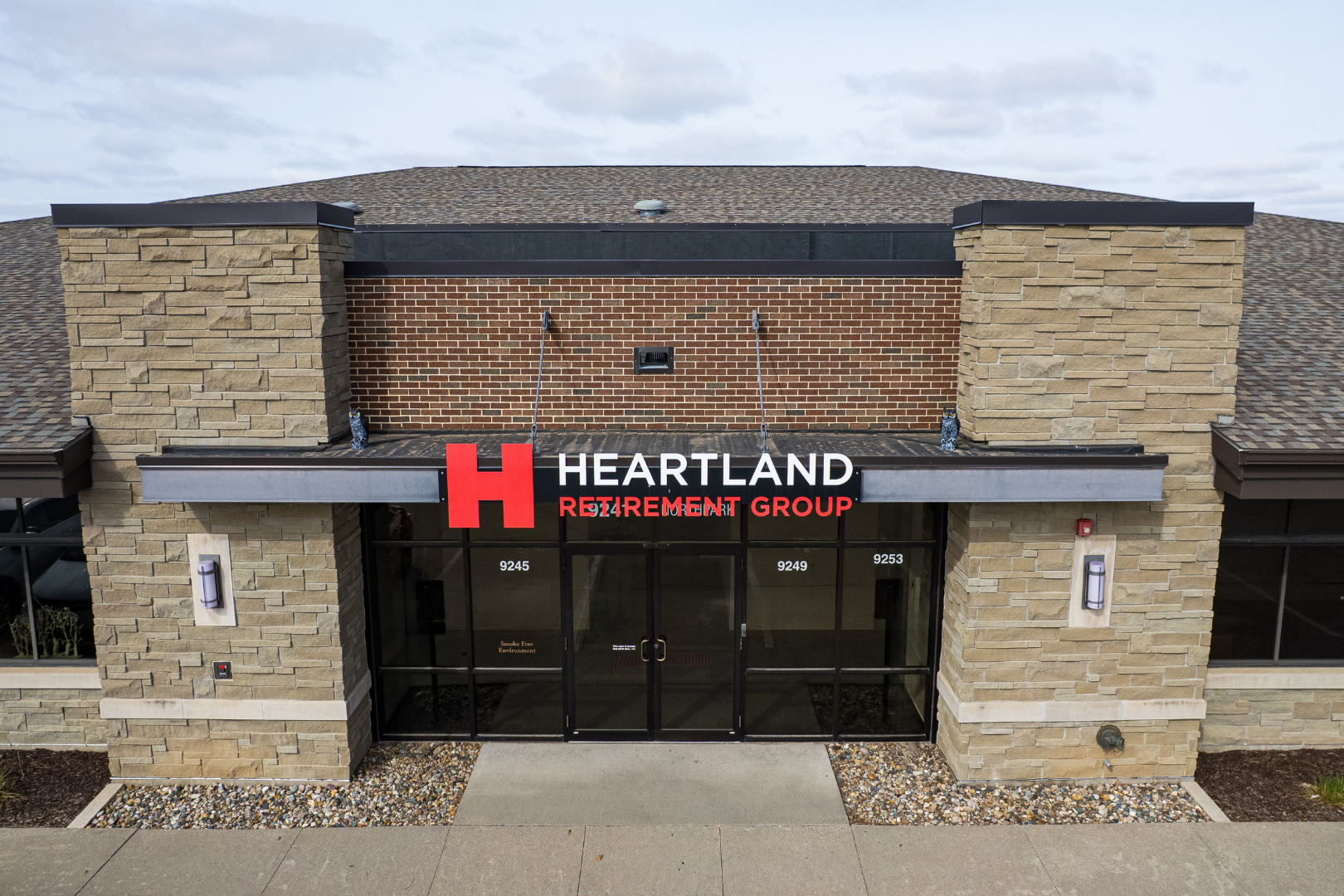 A group of people are walking across a bridge over a river in a park.