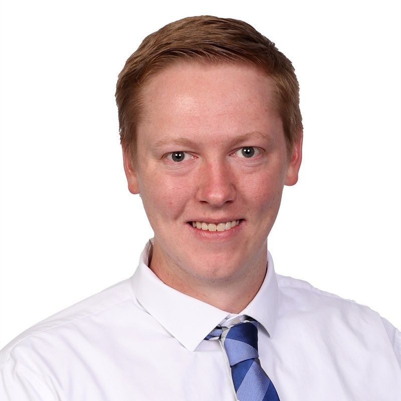 A man in a suit and tie is smiling for the camera.