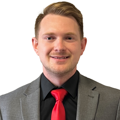 A man in a suit and tie is smiling for the camera.