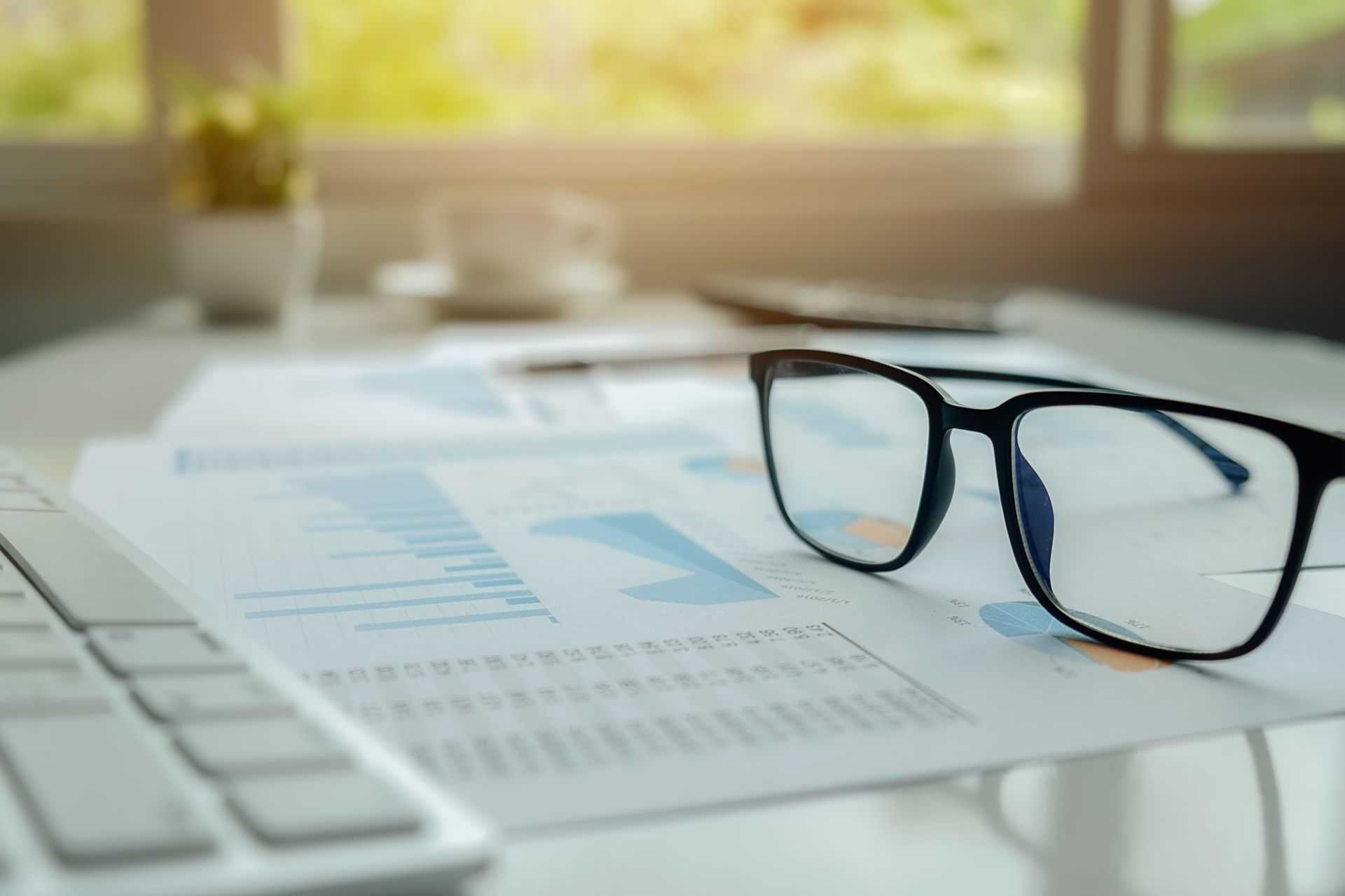 A woman is carrying a little girl on her shoulders in a field at sunset.