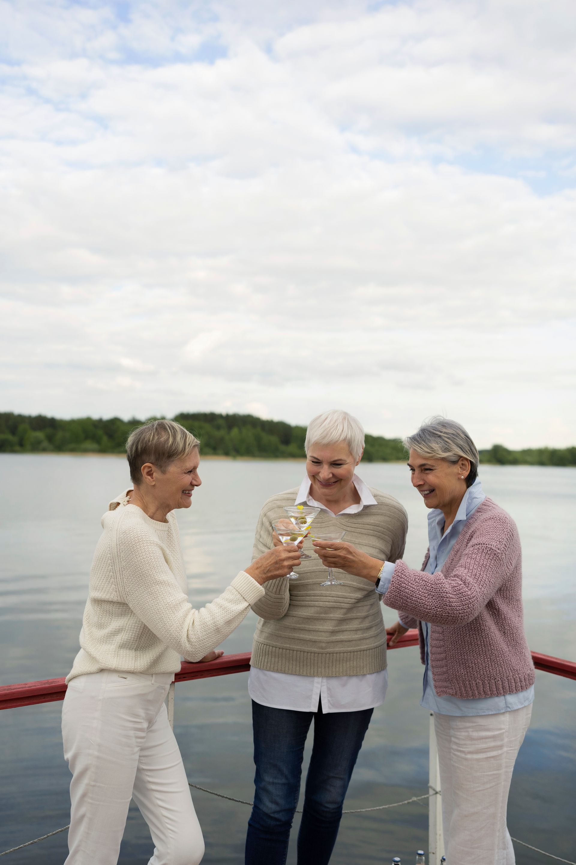A woman is carrying a little girl on her shoulders in a field at sunset.