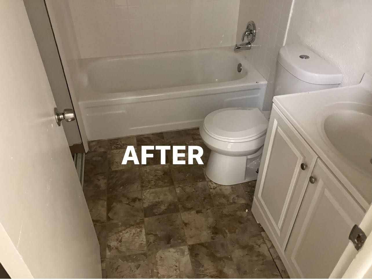 Bathroom after cleaning, with tub, toilet, sink cabinet, and brown tile floor.