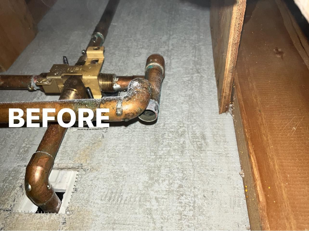 Rusty plumbing pipes under a floor, labeled “BEFORE” on the left.