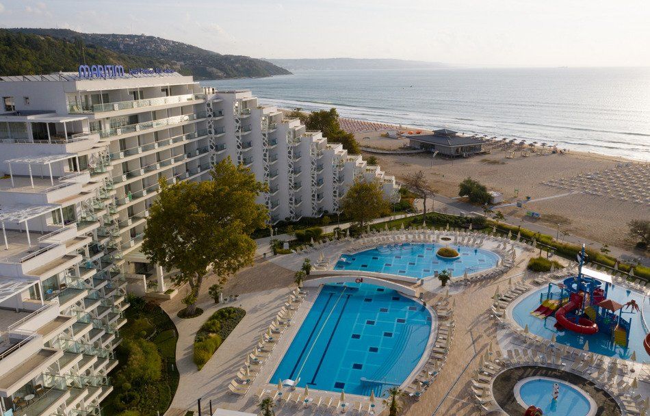 An aerial view of a hotel with swimming pools and a water slide.