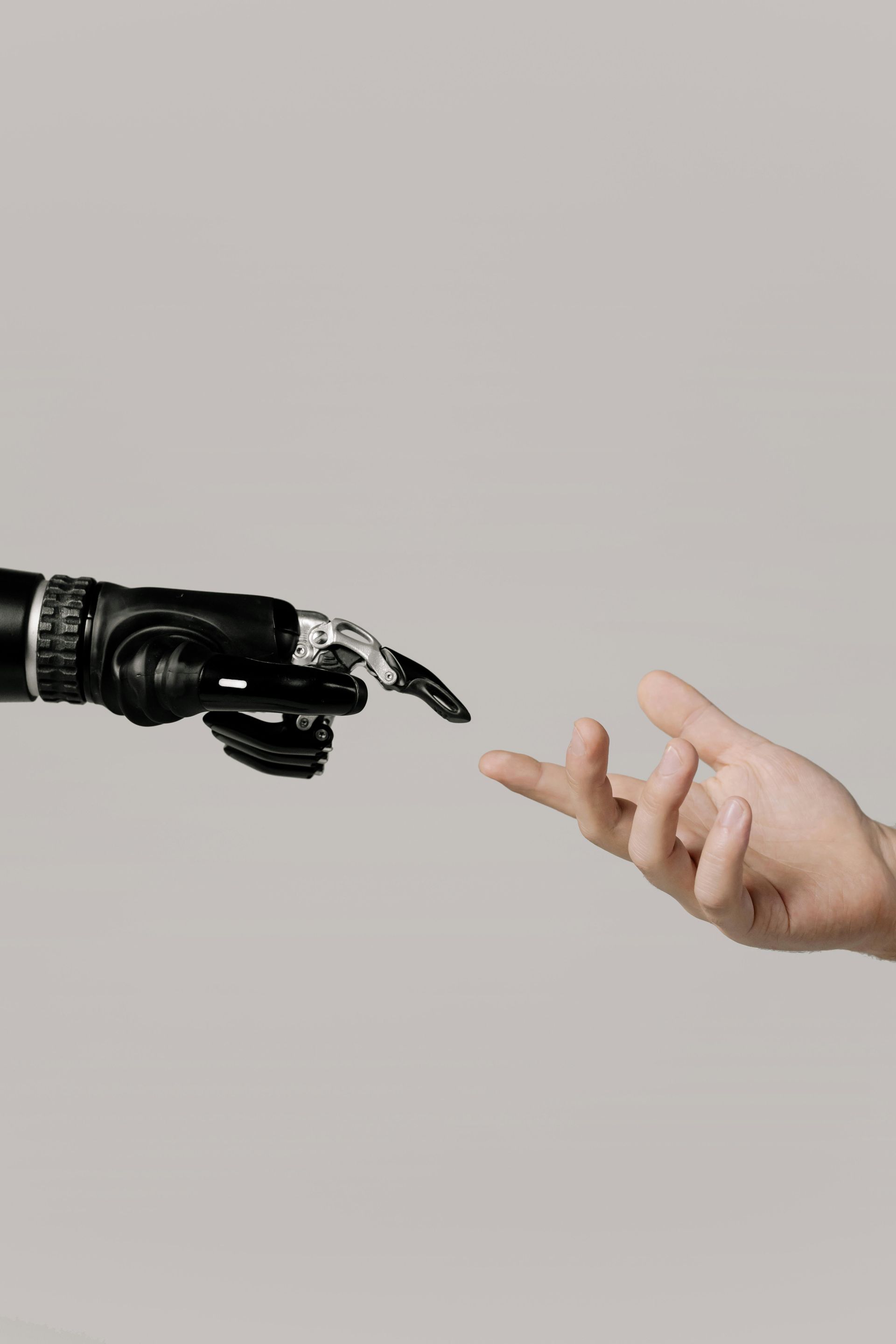 A robotic hand is reaching out to a human hand.