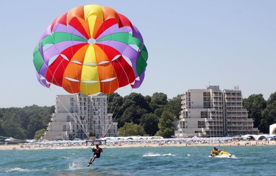 A person is parasailing over a body of water