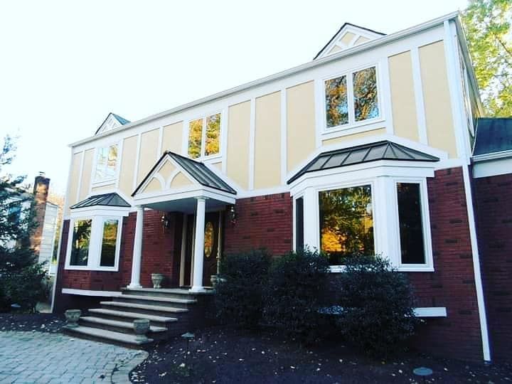 Two-story brick building with white trim and a small front stoop under a bright sky