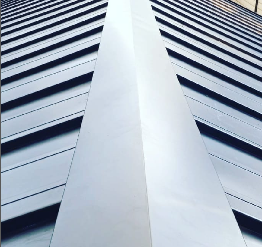 Modern high-rise building facade with a white central column and dark horizontal windows