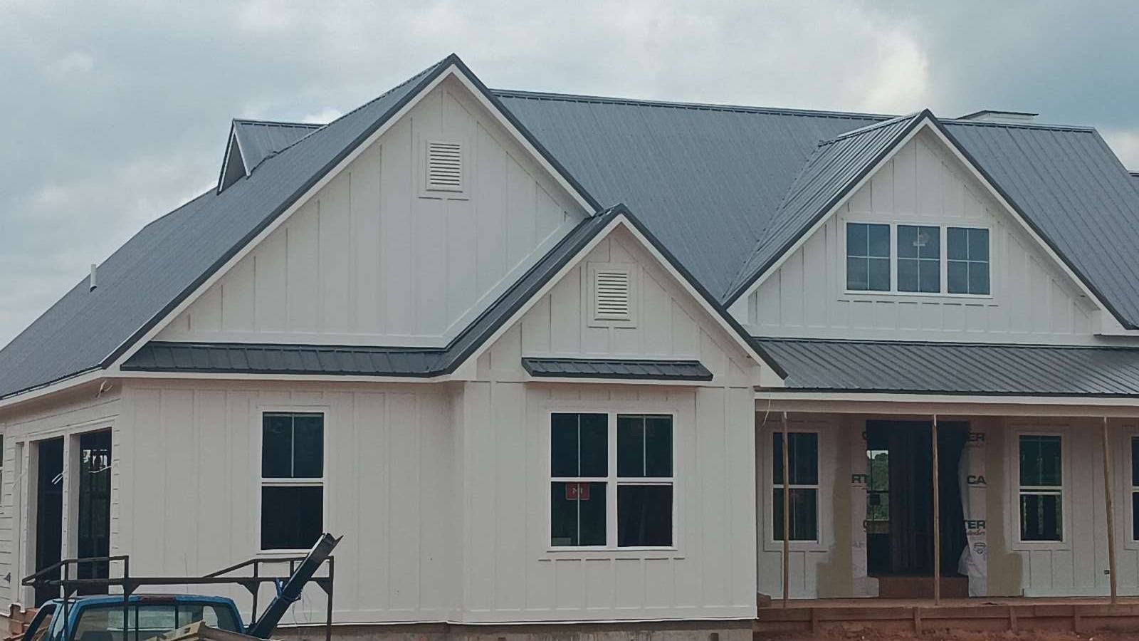 New white house with gray roof and front porch under construction