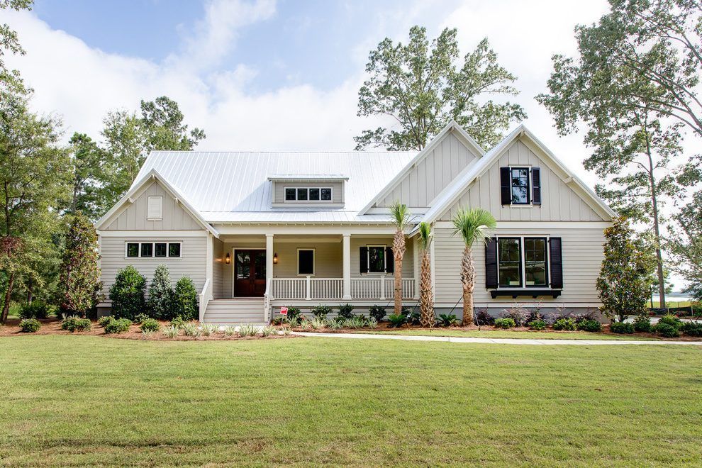 Single-story white house with a front porch, dark shutters, and a large green lawn