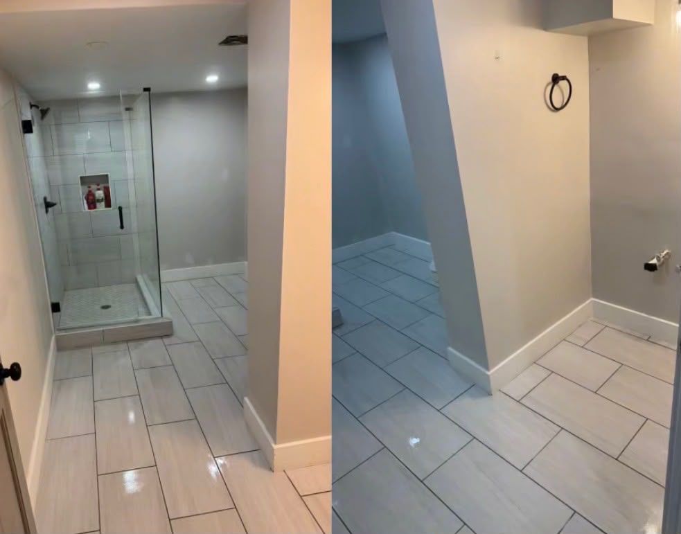 Small bathroom with white tile floor, glass shower, toilet, and a wall-mounted ring fixture.