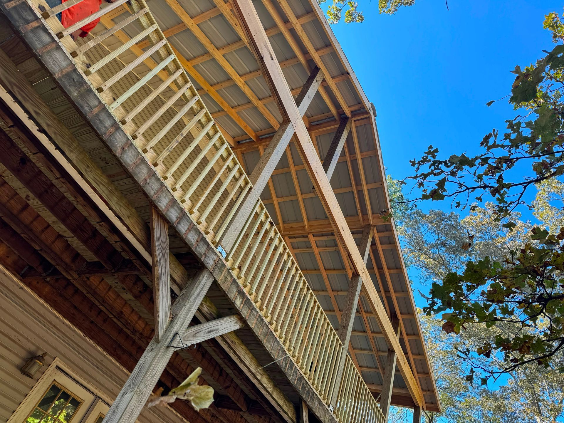 Low-angle view of a wooden building with a sloped roof against a bright blue sky