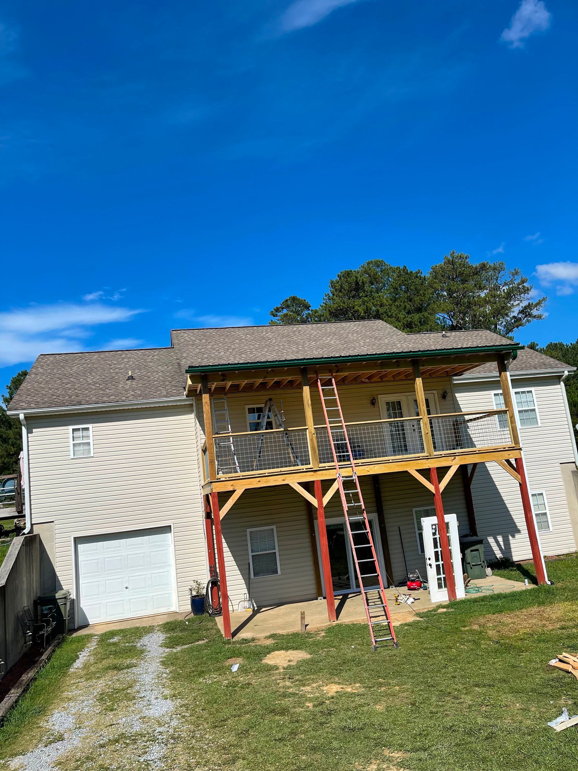 House under repair with scaffolding and ladder, beneath a blue sky