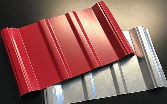 Red and silver corrugated metal roofing sheets stacked together