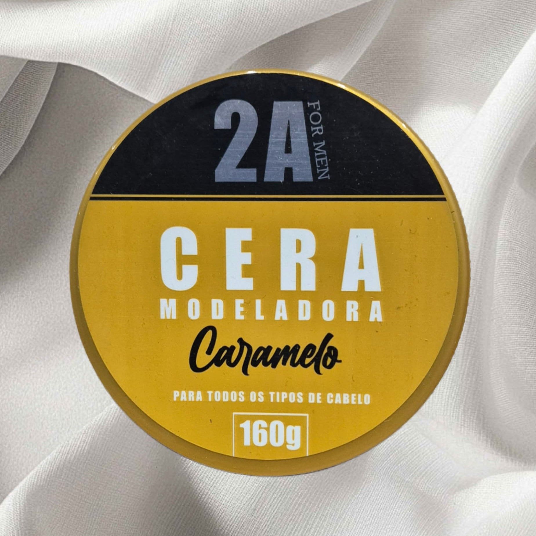 Frasco redondo de cera para peinar, dorado con etiqueta negra.