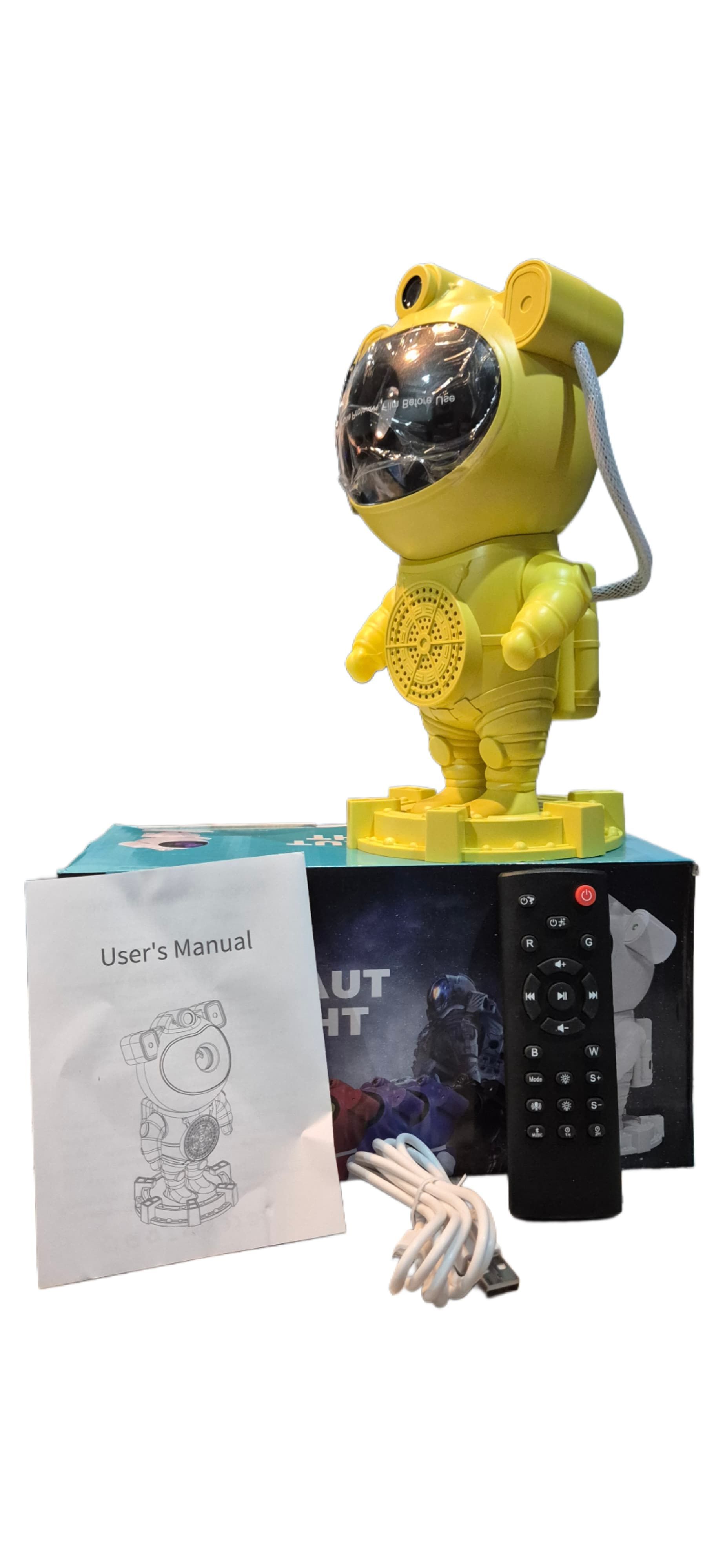 Proyector de luz de estrellas de color rosa con forma de astronauta sobre una caja.