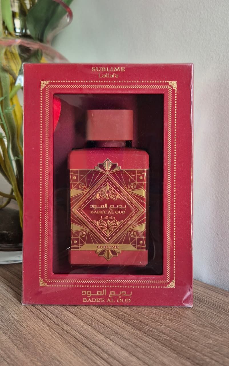 Frasco de perfume rojo sobre fondo dorado satinado.