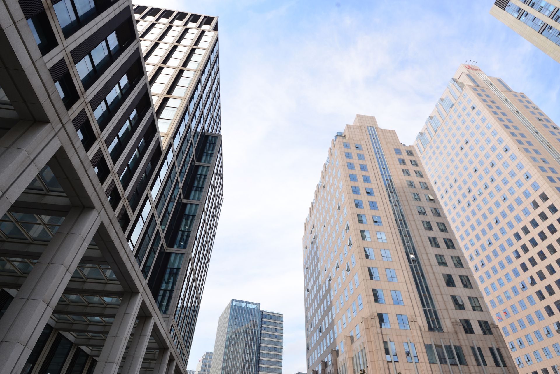 Looking up at a group of tall buildings in a city.