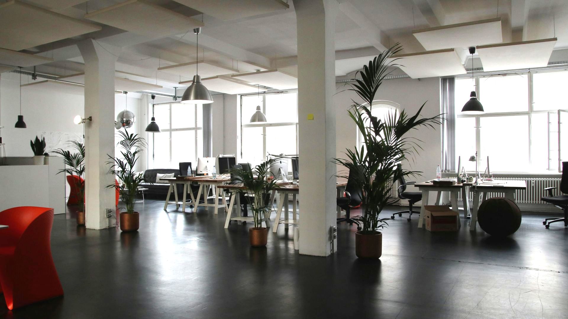 A large office room with a lot of tables and chairs