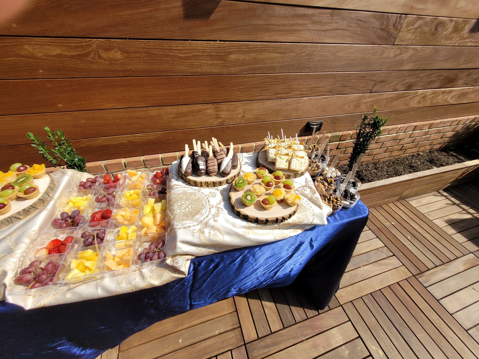 A table with plates of food on it is on a wooden deck.