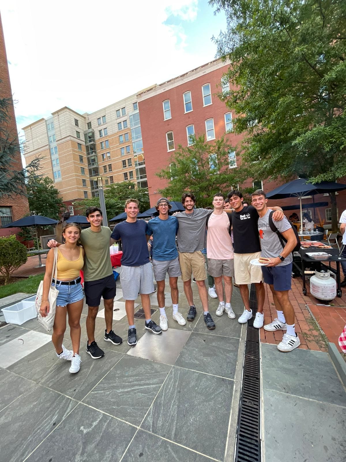 A group of young people are posing for a picture in front of a building.