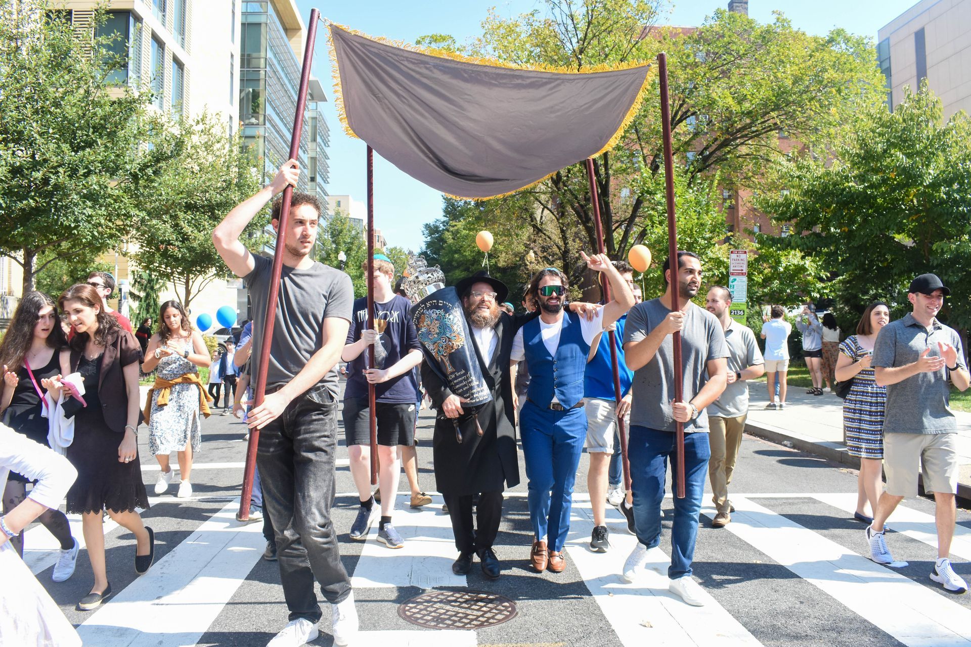 A group of people are walking down a street holding a flag.