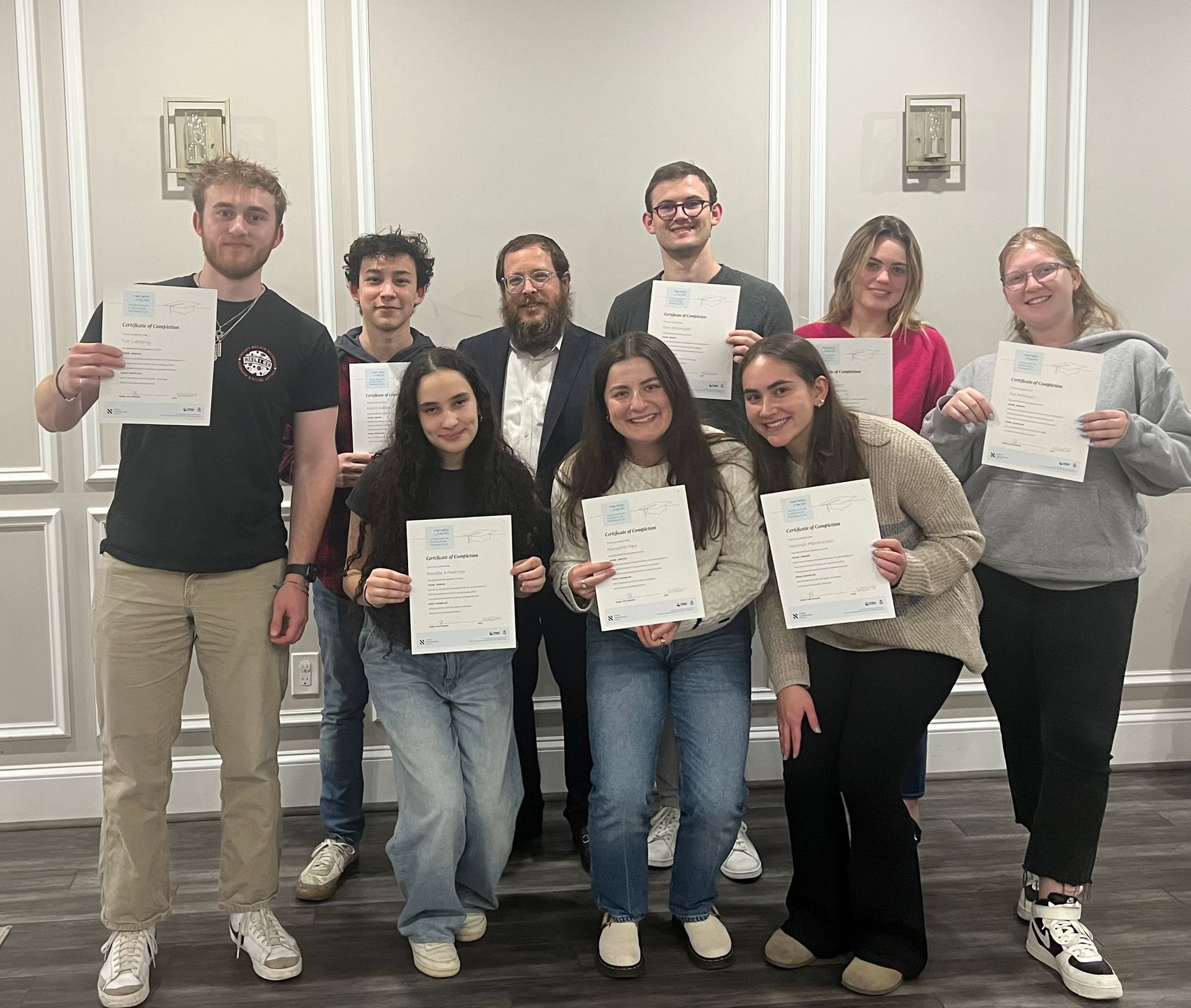 A group of people are posing for a picture while holding papers.