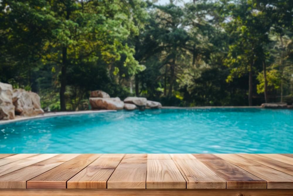 A Wooden Deck With A Swimming Pool In The Background — All Bright Pool Care In Laurieton, NSW