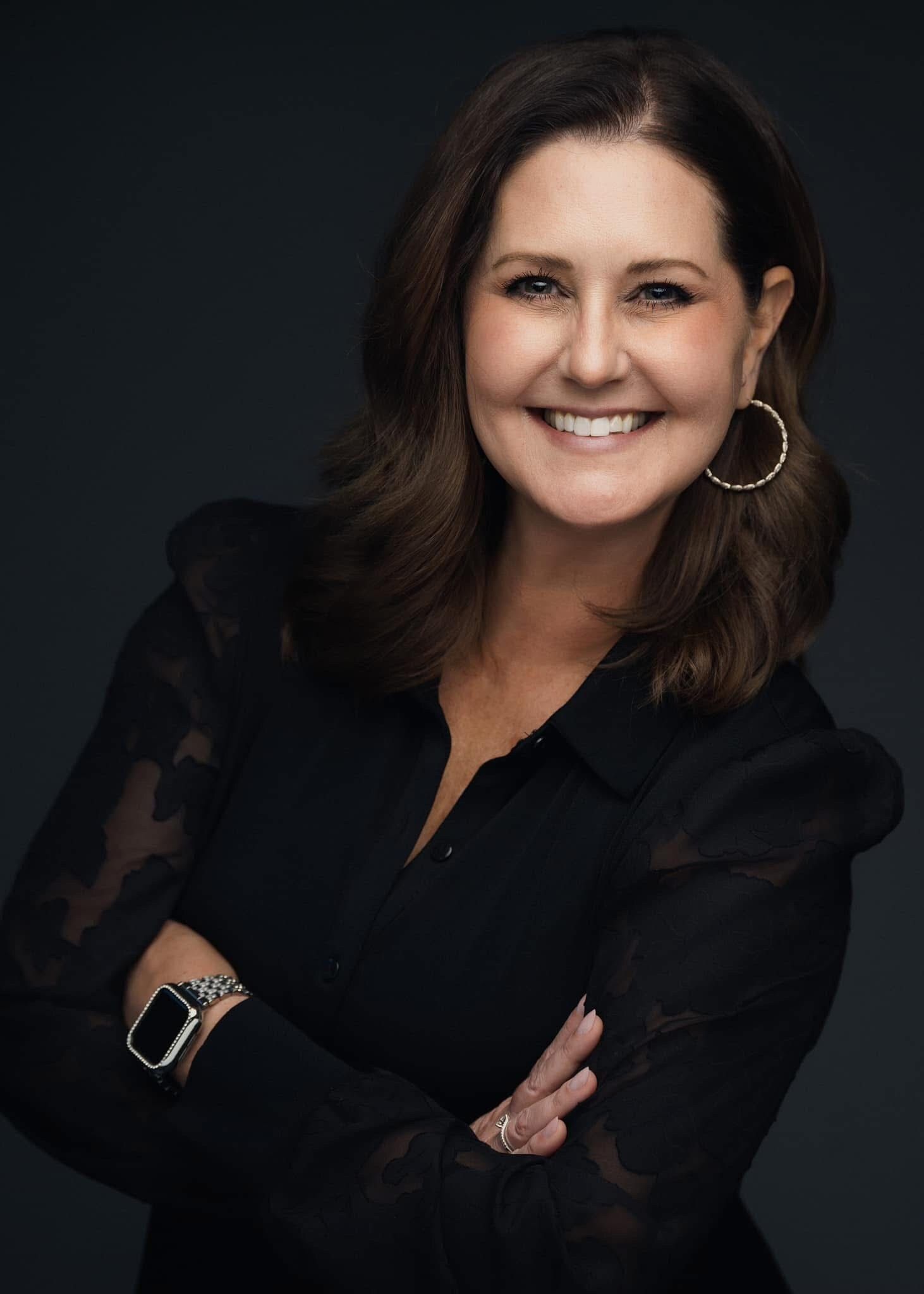 A silhouette of a woman with a bun in her hair at sunset