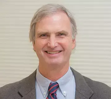 A man in a suit and tie is smiling for the camera.