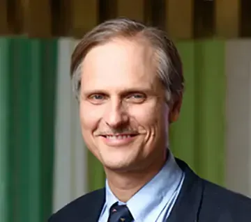 A man in a suit and tie is smiling for the camera.