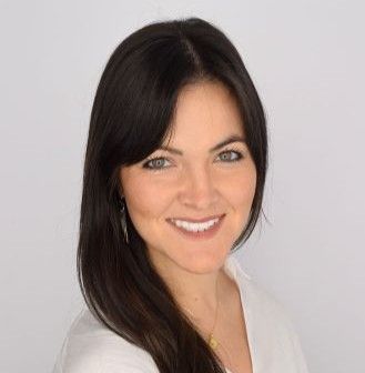 A woman in white shirt smiles for the camera
