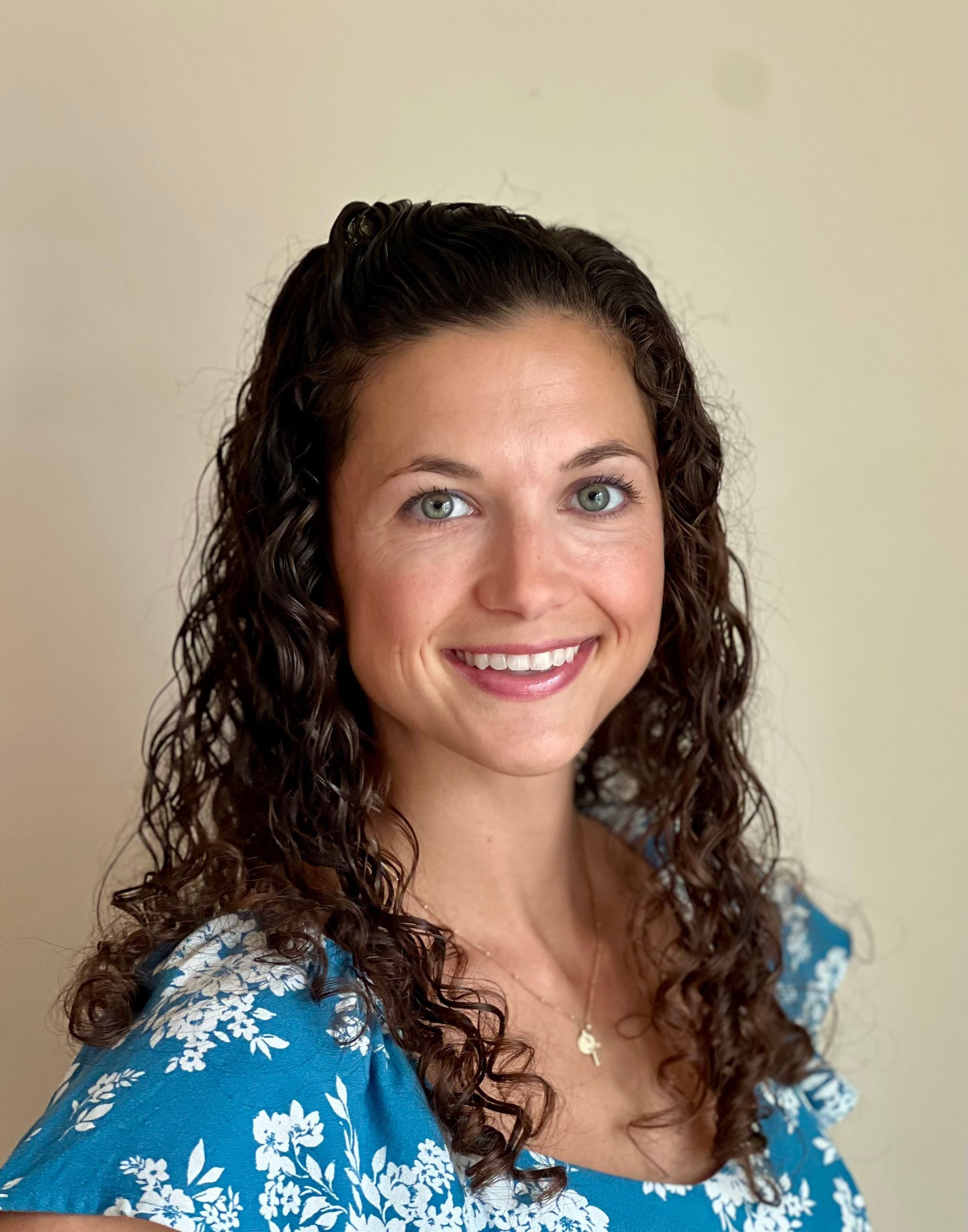 A woman in a blue shirt is smiling for the camera