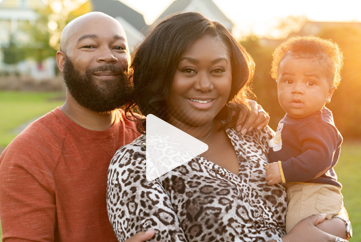 A man and a woman are holding a baby in their arms.