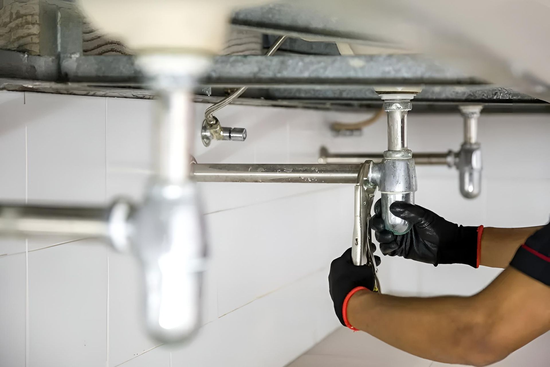 Plumber is Fixing a Sink Pipe in a Bathroom — Wet & Dry Plumbing & Gas in Newtown, QLD