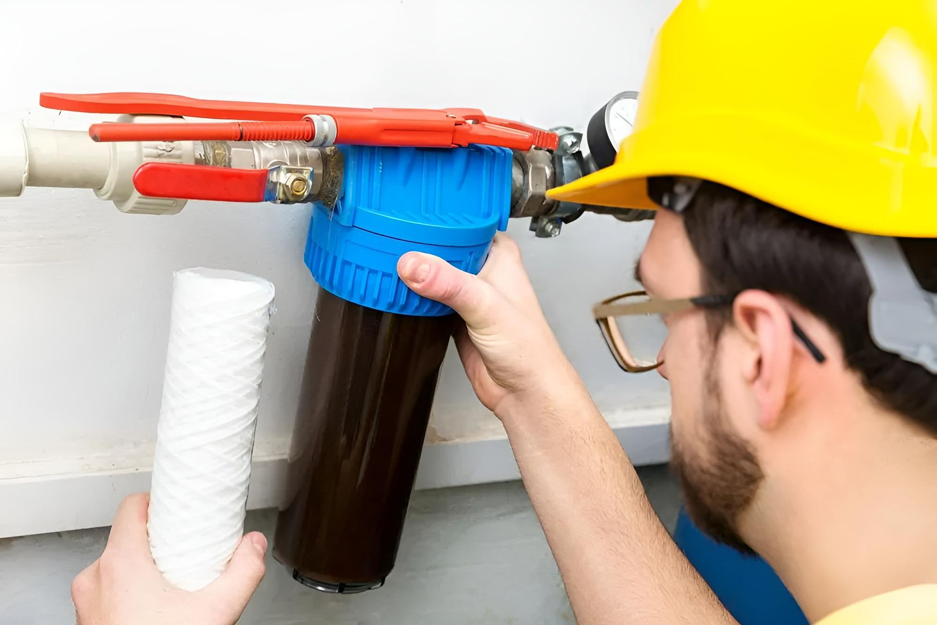 Man Wearing a Hard Hat is Fixing a Water Filter — Wet & Dry Plumbing & Gas in Gatton, QLD