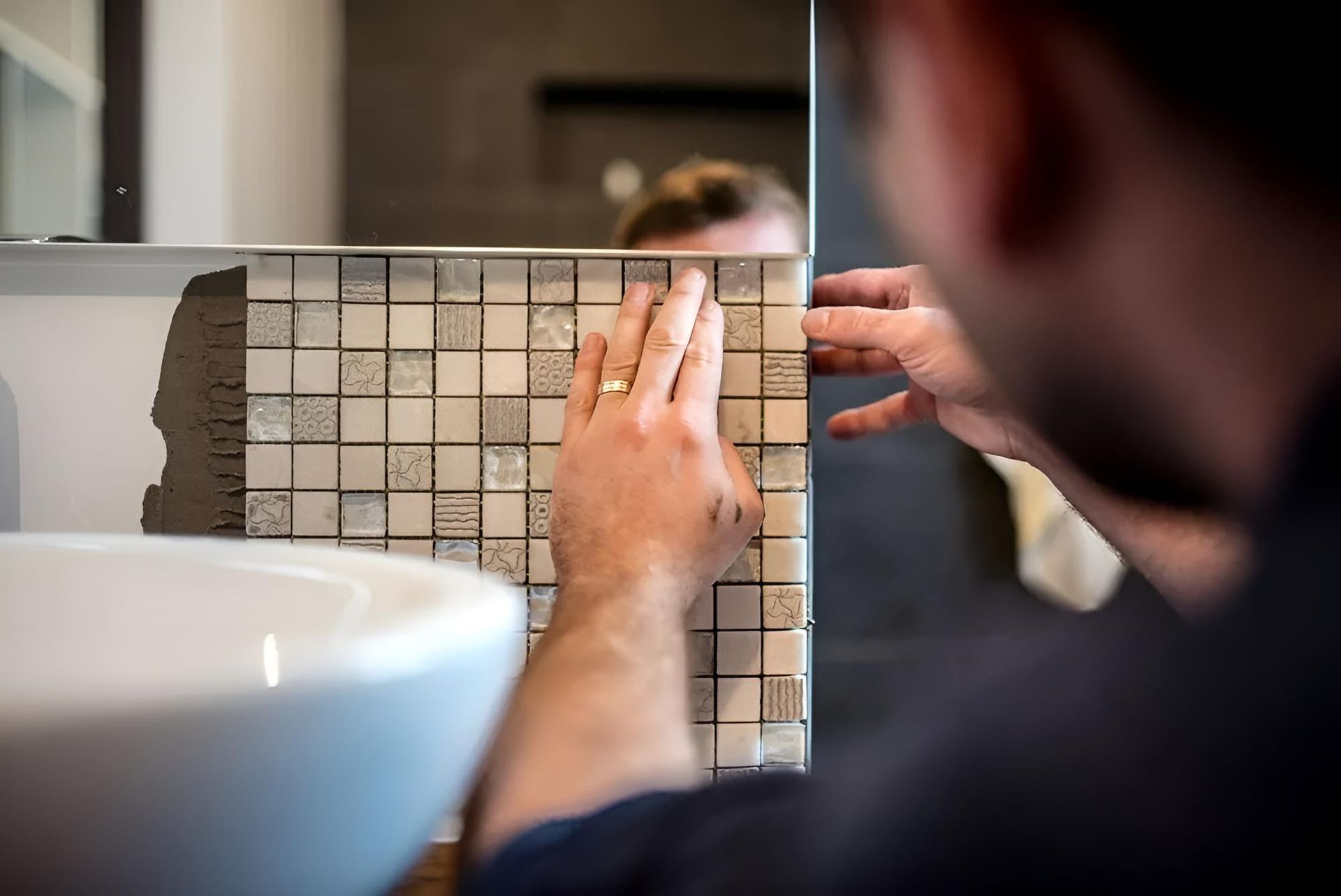 Man is Installing a Mosaic Tile in a Bathroom — Wet & Dry Plumbing & Gas in Highfields, QLD