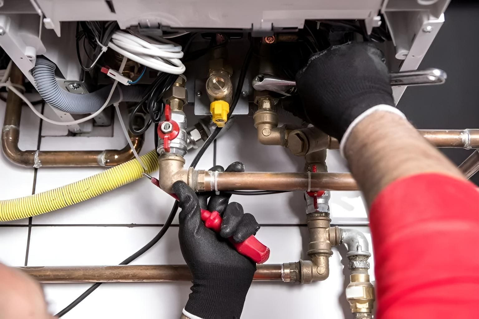 Plumber is Working on a Boiler With a Wrench — Wet & Dry Plumbing & Gas in Newtown, QLD