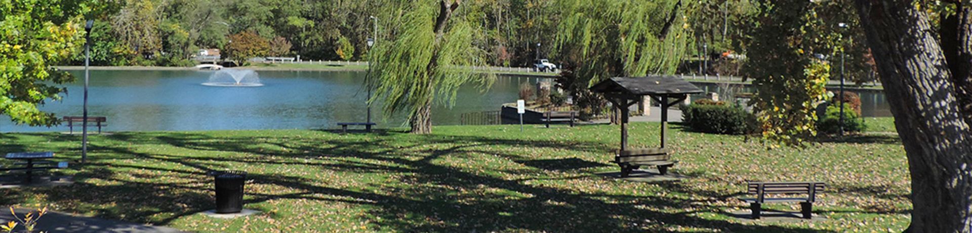 Person pouring white wine into a glass, outdoors.