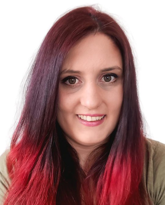 Woman with long red-ombre hair, smiling at camera; wearing olive-green shirt against a white background.