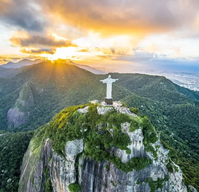 An aerial view of the statue of jesus on top of a mountain.