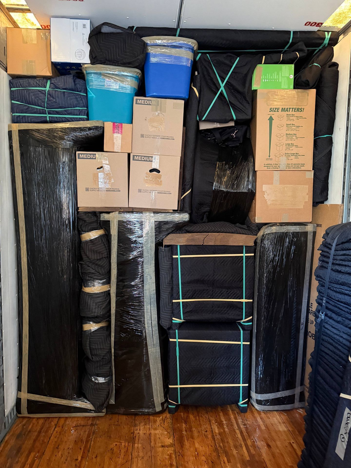 The inside of a moving truck filled with boxes and blankets.