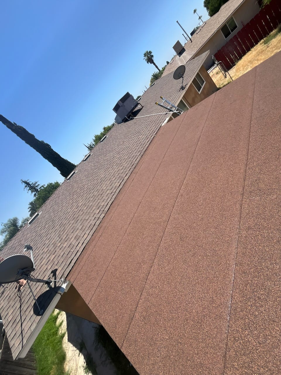Woman in straw hat smiles, holding wine glass near a lake.