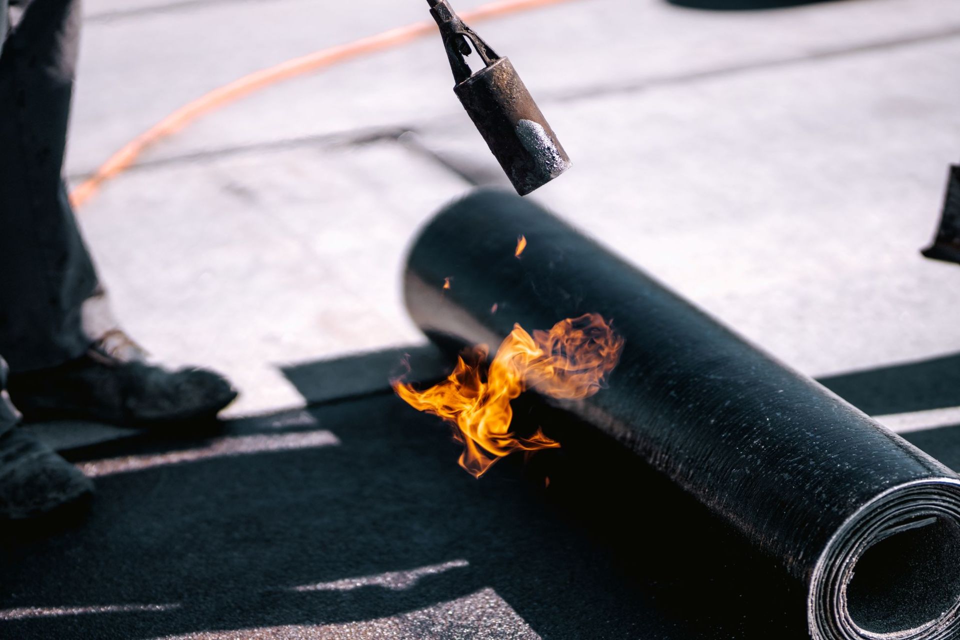 Woman in straw hat smiles, holding wine glass near a lake.