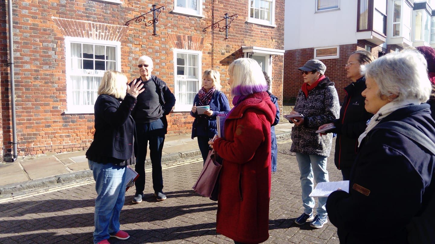 A group of people are standing in front of a brick building.