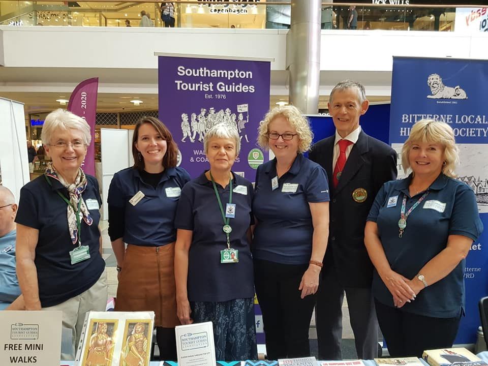 A group of people are posing for a picture in front of a table.